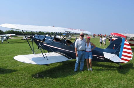 Sam and Mindy Lyons pose in front of an airplane.