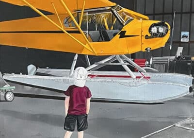 "Childhood Dreams" by Sam Lyons is a captivating new original artwork commissioned by a client. This piece is based on a photograph of the client's grandson during a visit to an airplane hangar. The painting vividly captures the boy's fascination as he gazes in awe and walks toward a striking yellow Cub on floats.